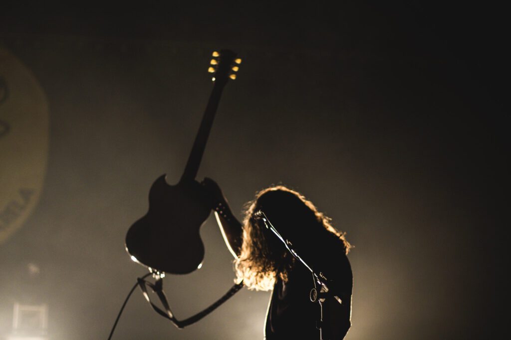 Imagem de uma sombra que mostra um homem carregando uma guitarra ao alto